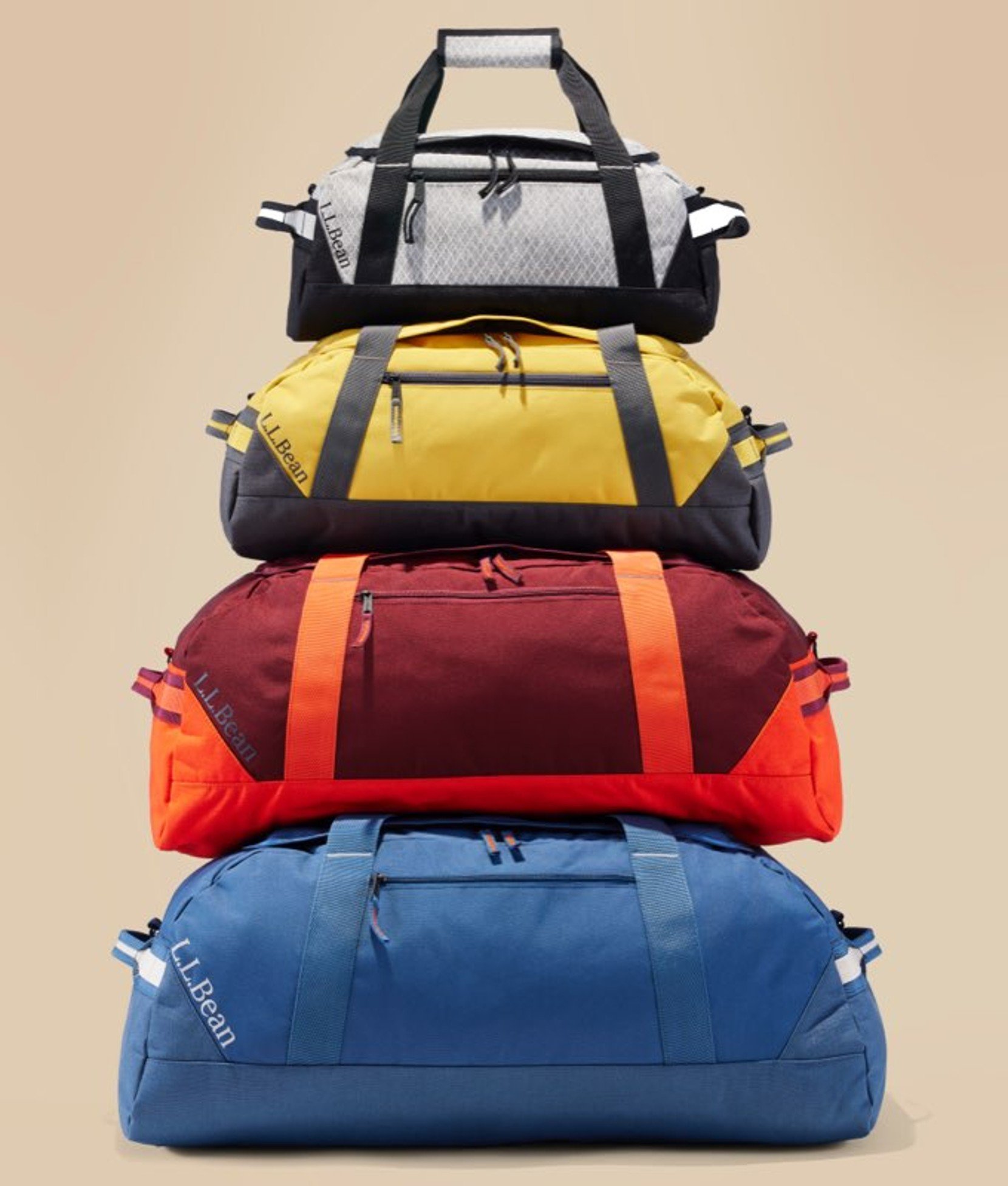 Stack of colorful duffel bags in yellow, blue, red, and black.