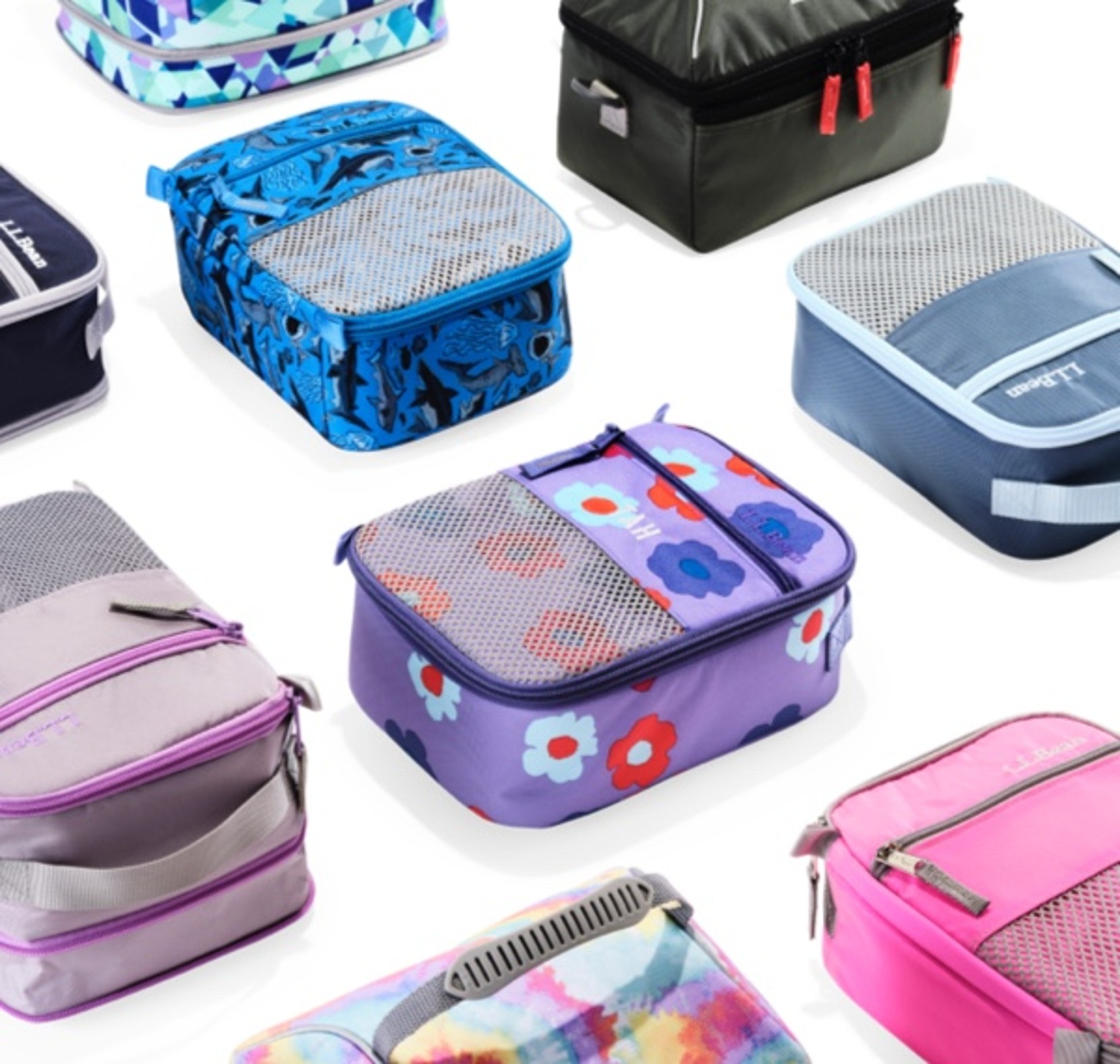 Assorted colorful lunch boxes with fun patterns arranged on a white background.