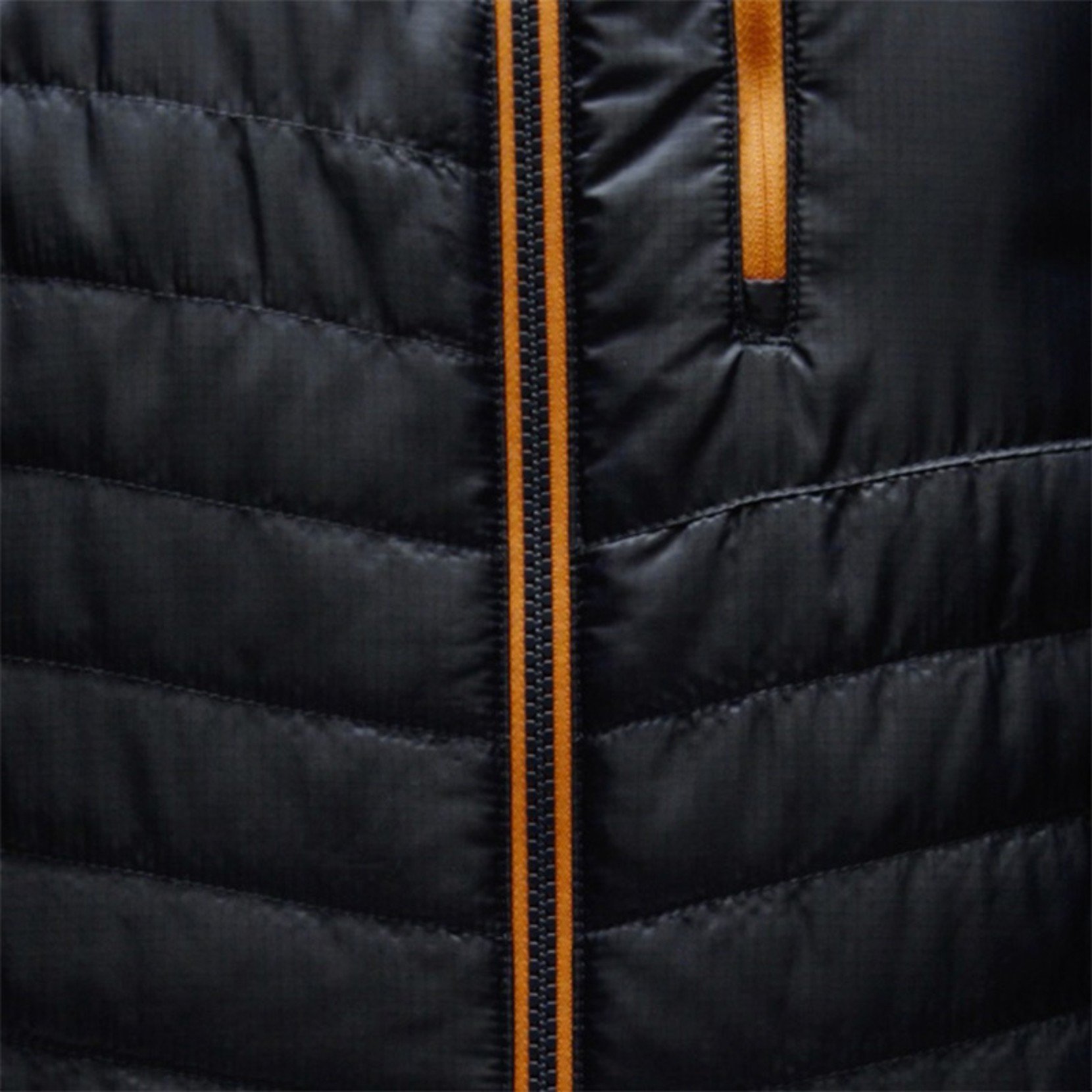 Close-up of black puffer jacket with orange zipper and pocket trim.