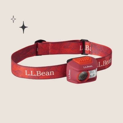 Red L L Bean headlamp with adjustable patterned strap and two light lenses.