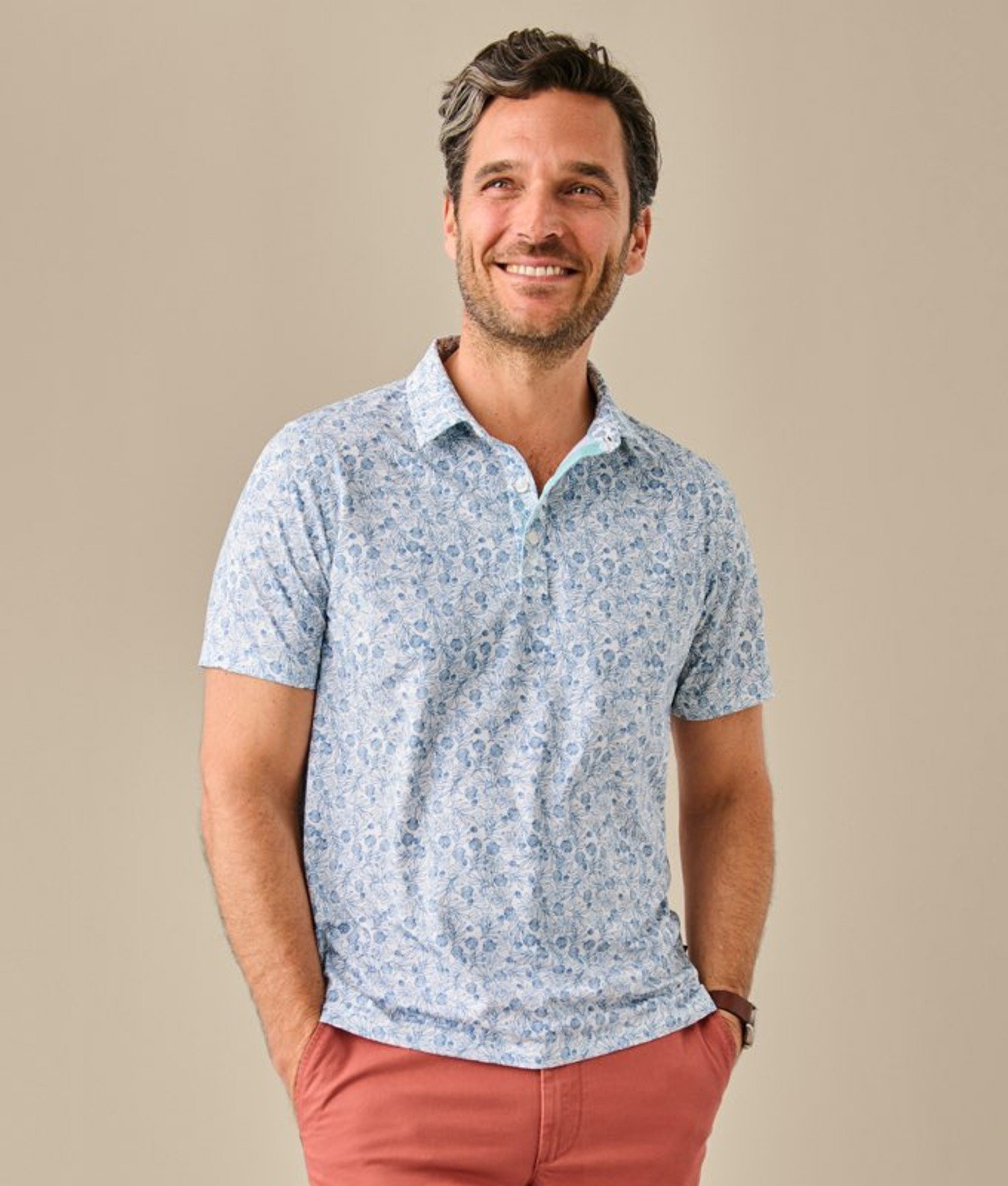 Light blue men’s polo shirt worn by a model smiling. 