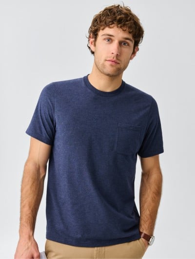 A thigh-up shot of a man wearing a blue t-shirt.