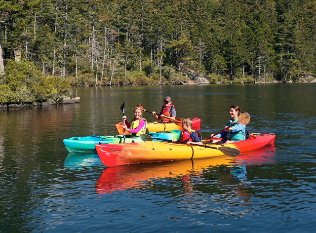 Group of people in colorful kayaks.