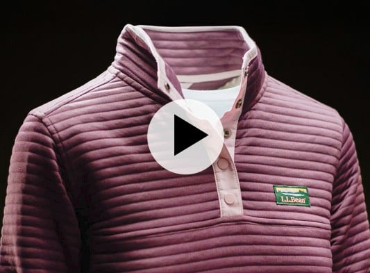Plum-colored ribbed pullover with a snap-button collar and L L Bean logo, shown on a mannequin against black background with play video icon.