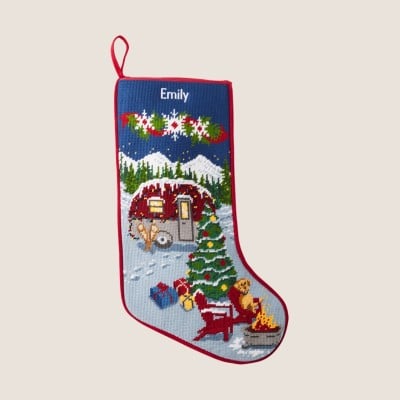Personalized holiday stocking with festive house and tree design.