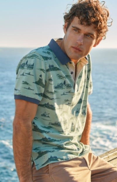 Waist up shot of man in blue printed polo shirt.