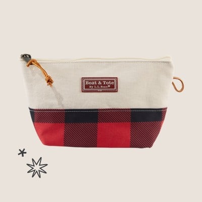 Small canvas pouch with red and black plaid bottom and leather zipper pull.