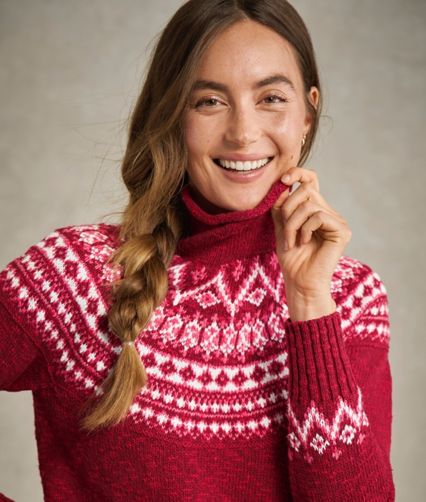 Woman in red sweater with white snowflake pattern.