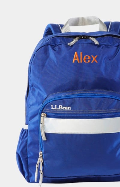 Close-up of a blue school backpack with "Alex" monogrammed on it.
