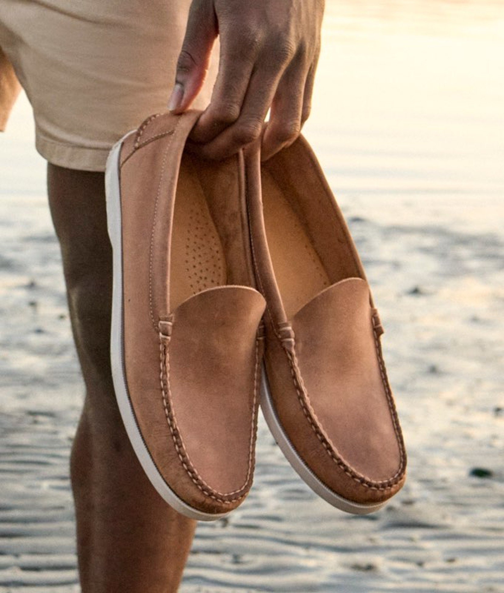 Pair of brown leather slip-on shoes shown in close-up against a neutral background.