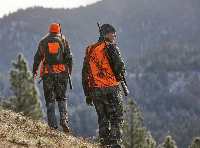 Two hunters on a hillside.