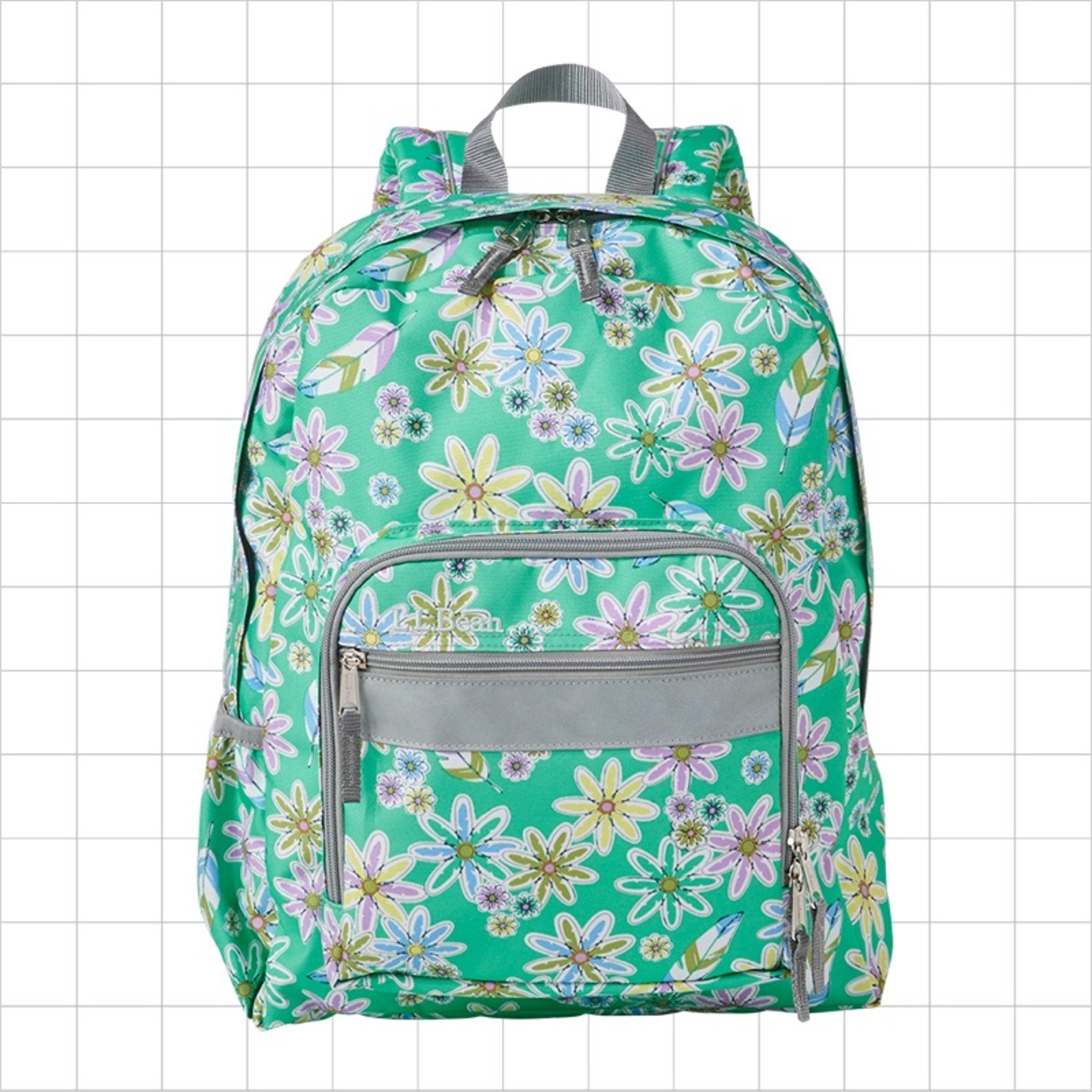 A green and flower school backpack with a reflective strip on the front pocket.