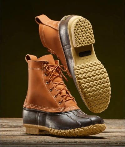 Tan and brown L L Bean boots with rubber soles; one boot upright, the other shows the textured sole.